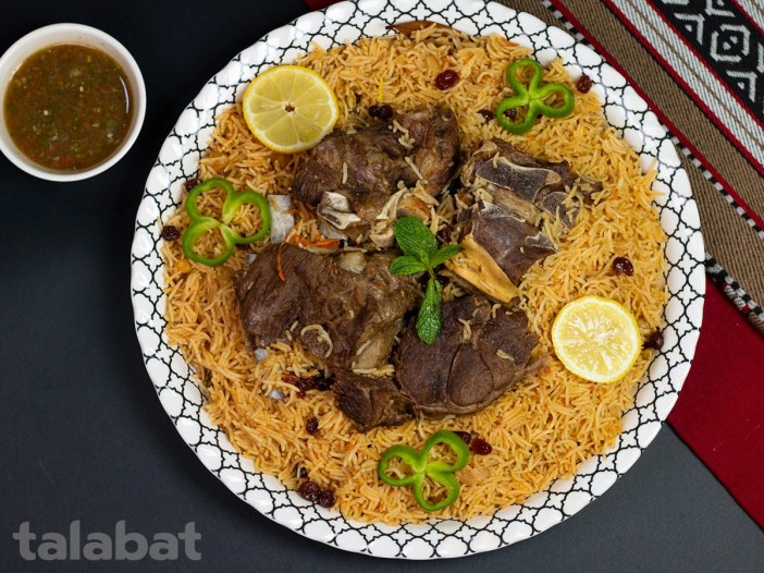 Slow-cooked Laham mutton shanks on saffron Bukhari rice with charred tomatoes, zhug sauce, and fried onions | Samarkandi Restaurant, Sitra