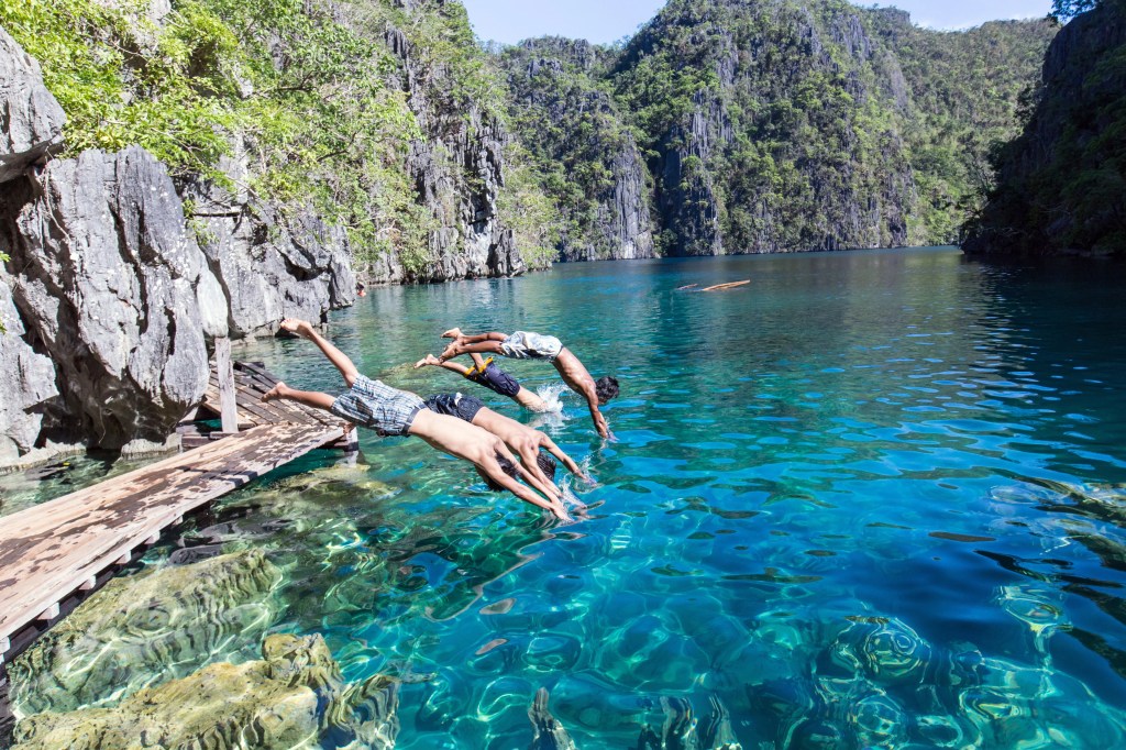 Kayaker exploring the turquoise waters of Twin Lagoon in Coron, Philippines