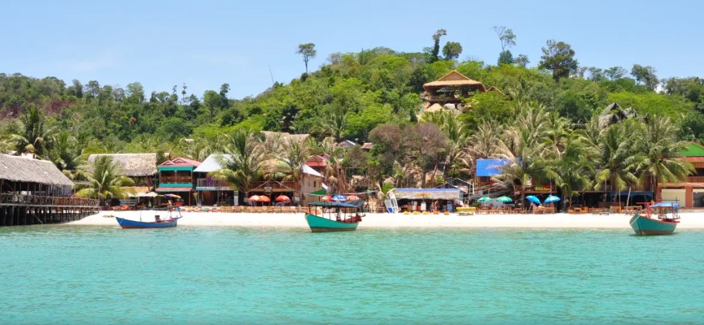 Long wooden pier stretching into the ocean during a golden sunset in Koh Rong