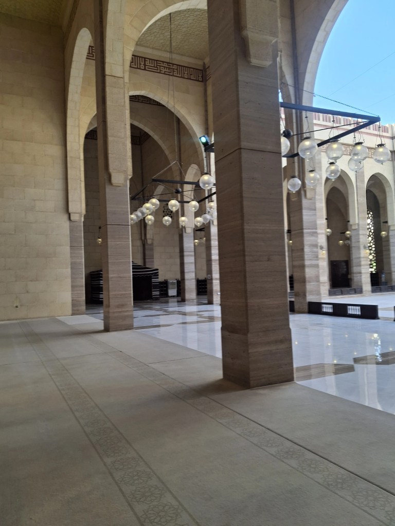 This image showcases the majestic interior of Al-Fateh Grand Mosque in Manama, Bahrain, where craftsmanship meets spiritual serenity. Featuring a grand chandelier, Arabic calligraphy, and arched ceilings, the mosque’s design reflects a perfect blend of tradition and artistic excellence—offering travelers not just a visual feast, but a moment of peaceful reflection.