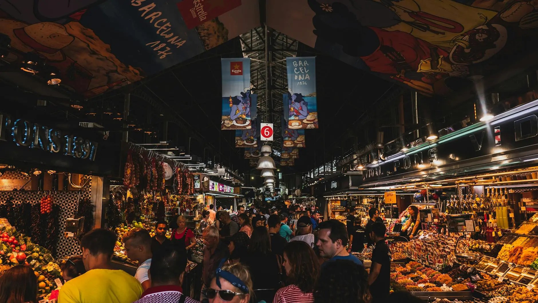 A bustling market in Barcelona, filled with vibrant stalls offering fresh fruits, vegetables, and local delicacies, with a lively crowd of shoppers enjoying the atmosphere.