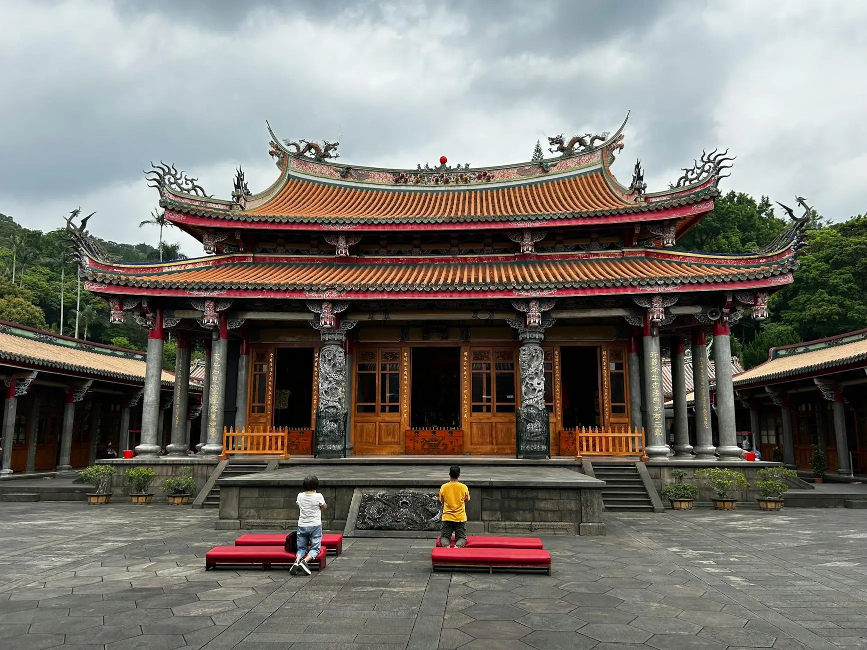 Exterior view of Longshan Temple in Taipei, showcasing traditional architecture with intricate wooden details and colorful roof decorations.