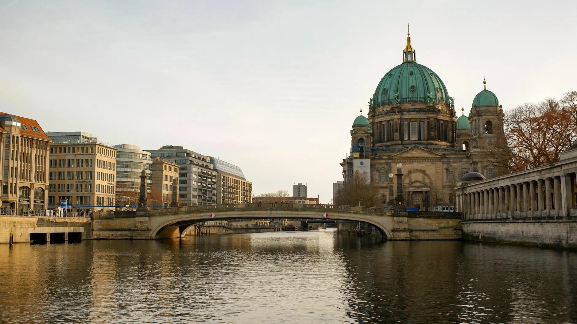 View of the Berlin Cathedral and a bridge over the Spree River, showcasing a blend of historic and modern architecture.
