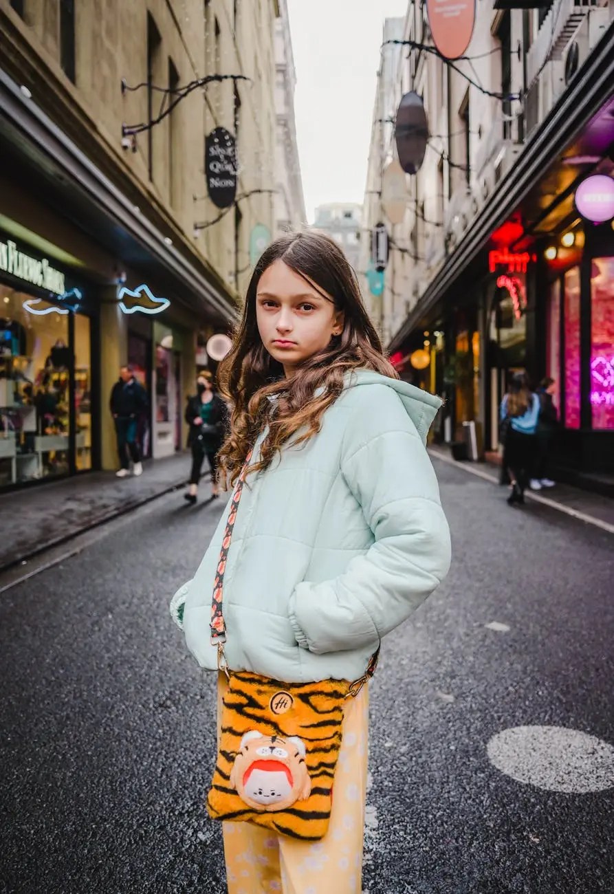 A young girl stands confidently in a Melbourne laneway, wearing a light blue puffer jacket and holding a playful tiger-shaped handbag, with colorful shop signs and pedestrians in the background.