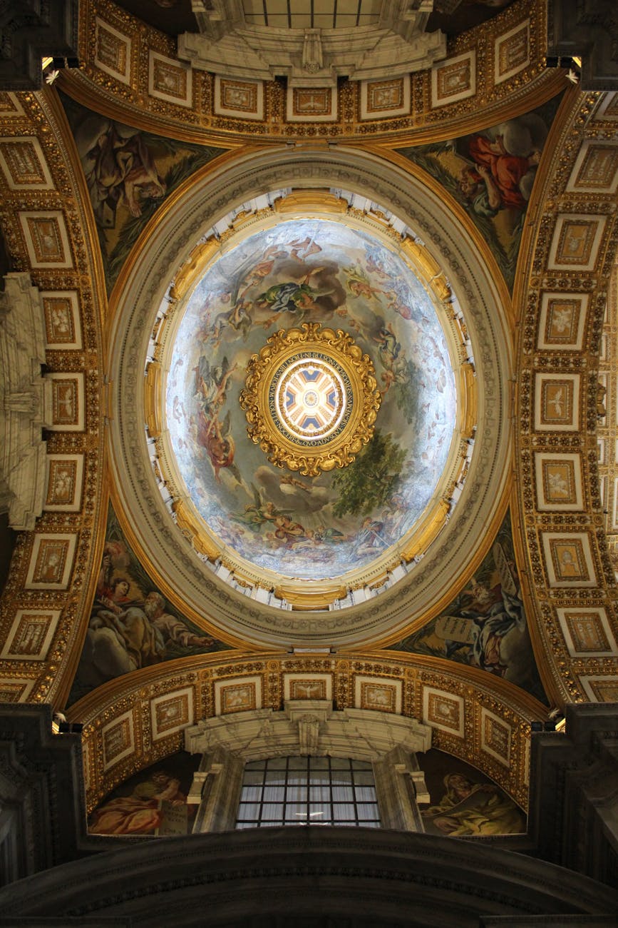 A view of the ornate ceiling of the Sistine Chapel, featuring intricate frescoes and a circular skylight.