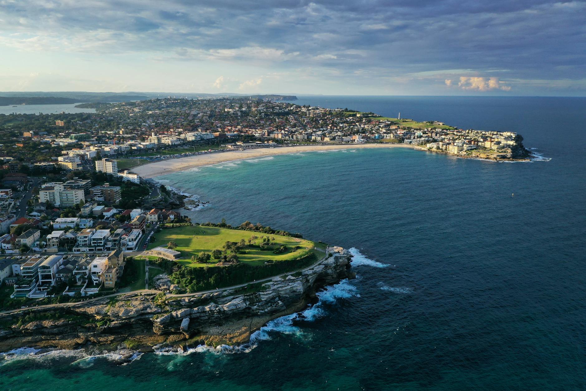 Aerial view of Bondi Beach, showcasing the coastline, surrounding buildings, and lush green areas.