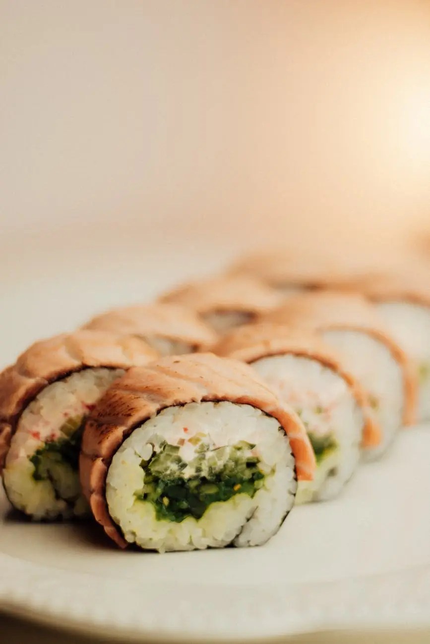 Close-up of sushi rolls arranged on a plate, featuring layers of fish and greens.
