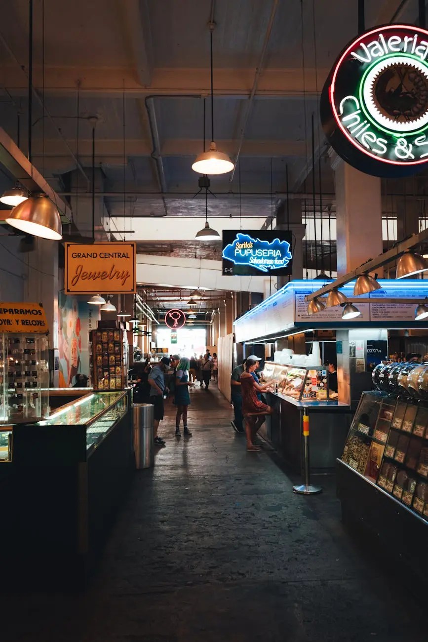 Interior view of a vibrant market showcasing various food stalls and shops, with customers browsing and interacting.