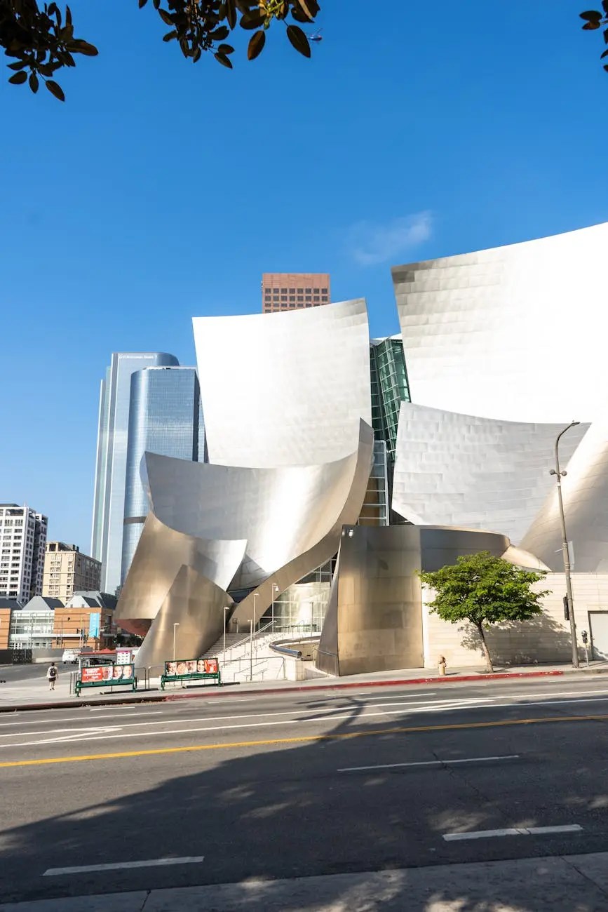 Exterior view of the Walt Disney Concert Hall in downtown Los Angeles, showcasing its unique, modern architectural design against a clear blue sky.