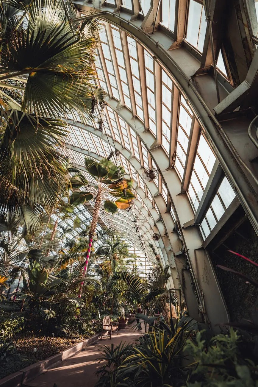 Interior view of a botanical garden featuring a glass ceiling and various tropical plants.