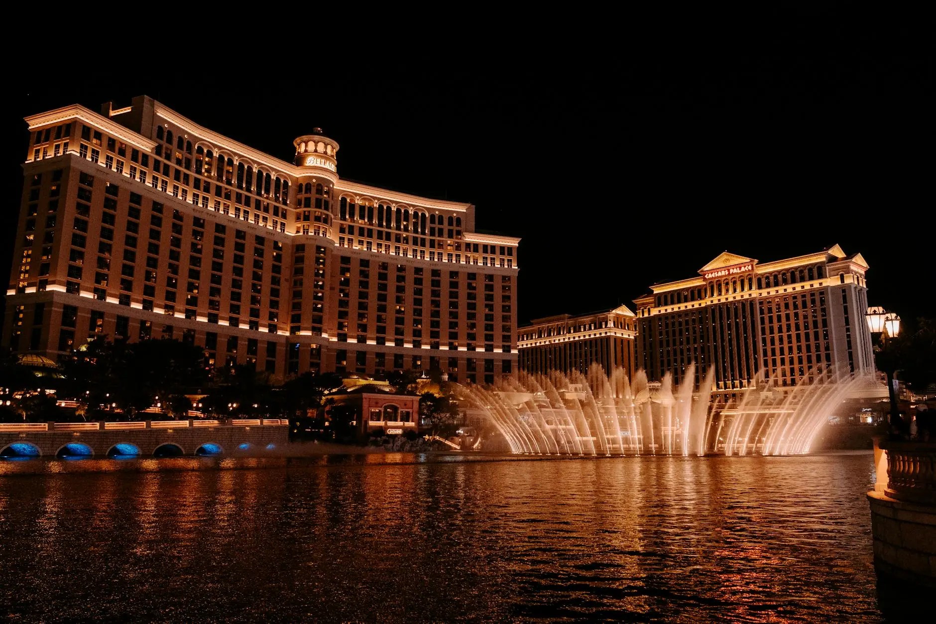 Nighttime view of the Bellagio Hotel with illuminated fountains in Las Vegas, showcasing its architecture and vibrant water display.