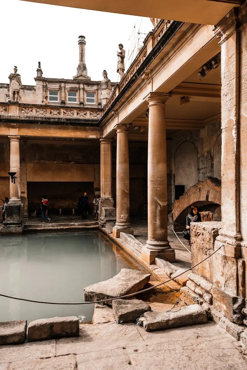 Interior of a historic thermal bath with Roman-style columns and statues, featuring a quiet mineral pool surrounded by stonework.