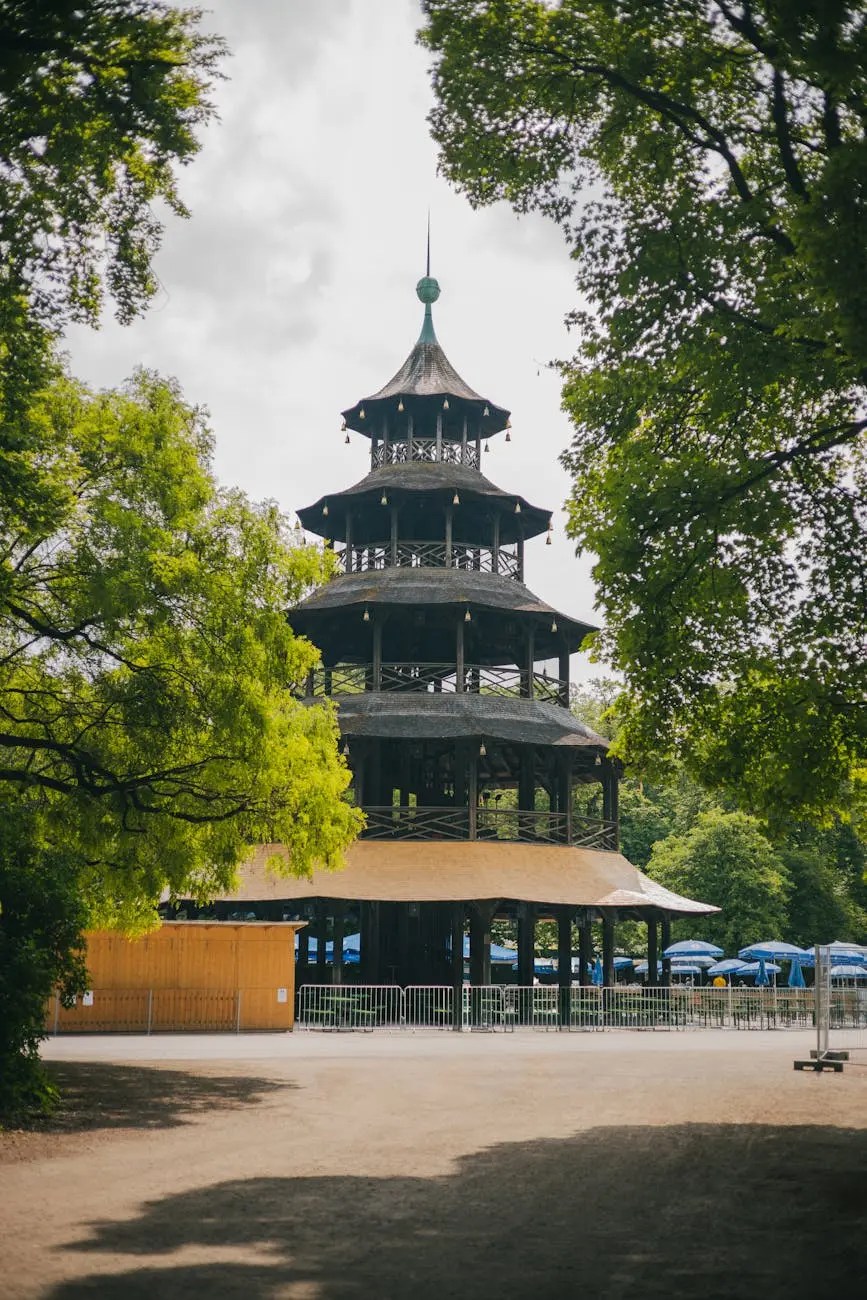 A wooden pagoda-style structure surrounded by greenery, located in a park setting in Munich, Germany.
