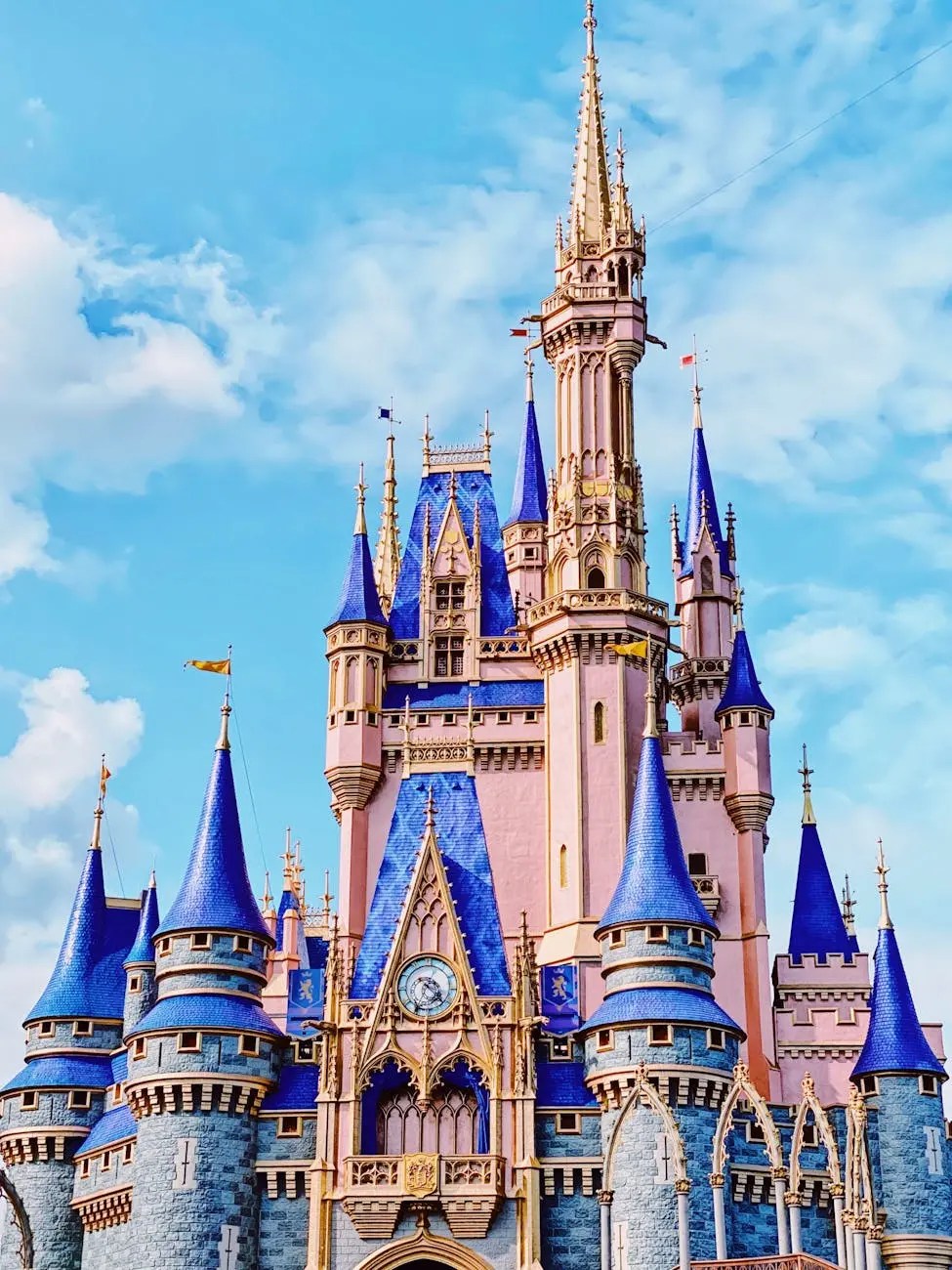 A close-up view of a fairytale castle with blue spires and golden accents against a blue sky.