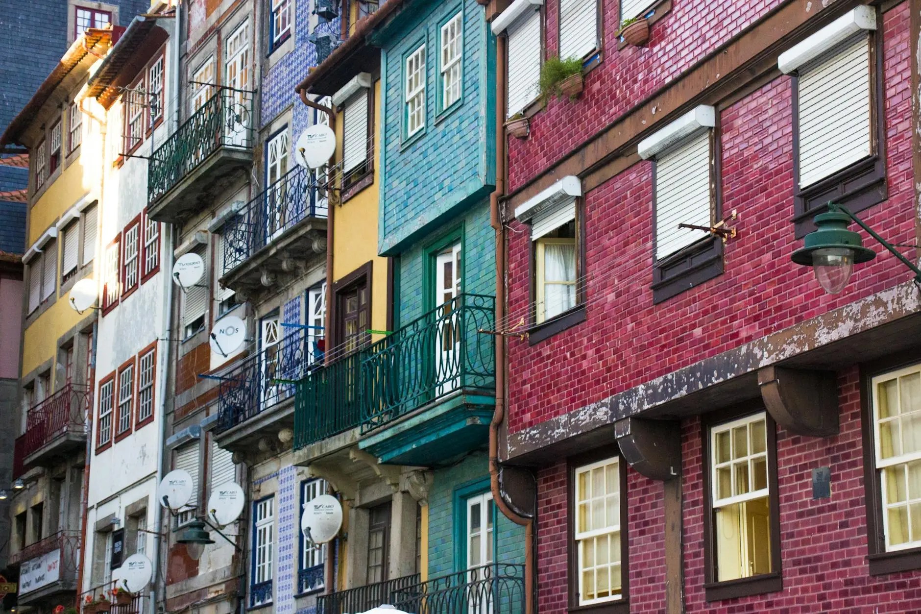 Colorful buildings with balconies and decorative tiles in a historic area of Porto, Portugal.