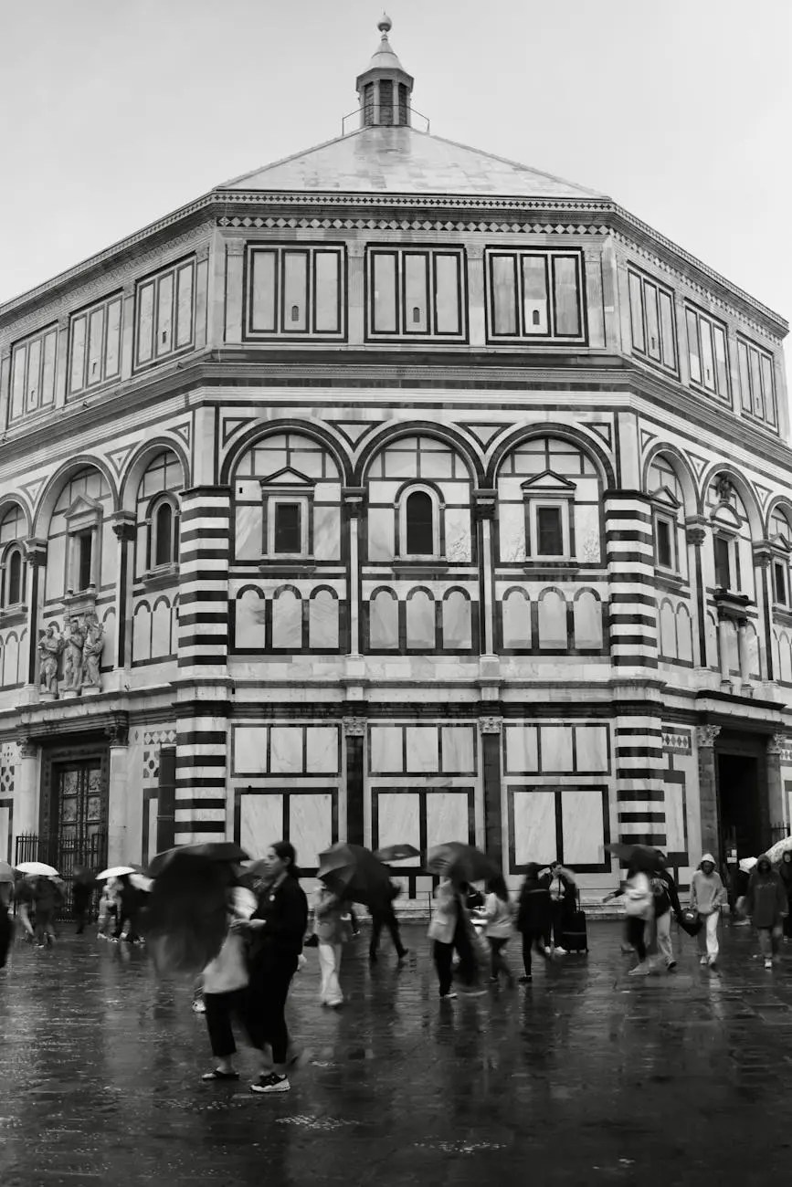 A black and white image of the Florence Baptistery, featuring its intricate architectural details and ornamental designs, with people walking in the rain, some carrying umbrellas.