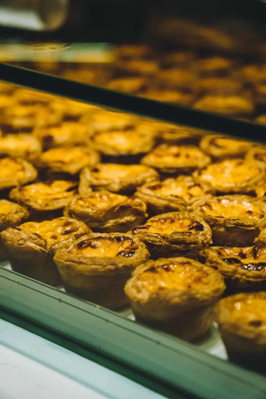 Close-up of baked egg tarts displayed in a glass case, showcasing their golden crusts and creamy filling.