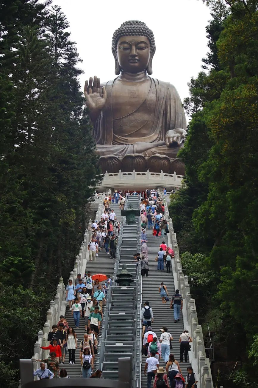 A crowd of tourists climbing the stairs leading to the Tian Tan Buddha statue on Lantau Island, surrounded by lush greenery.