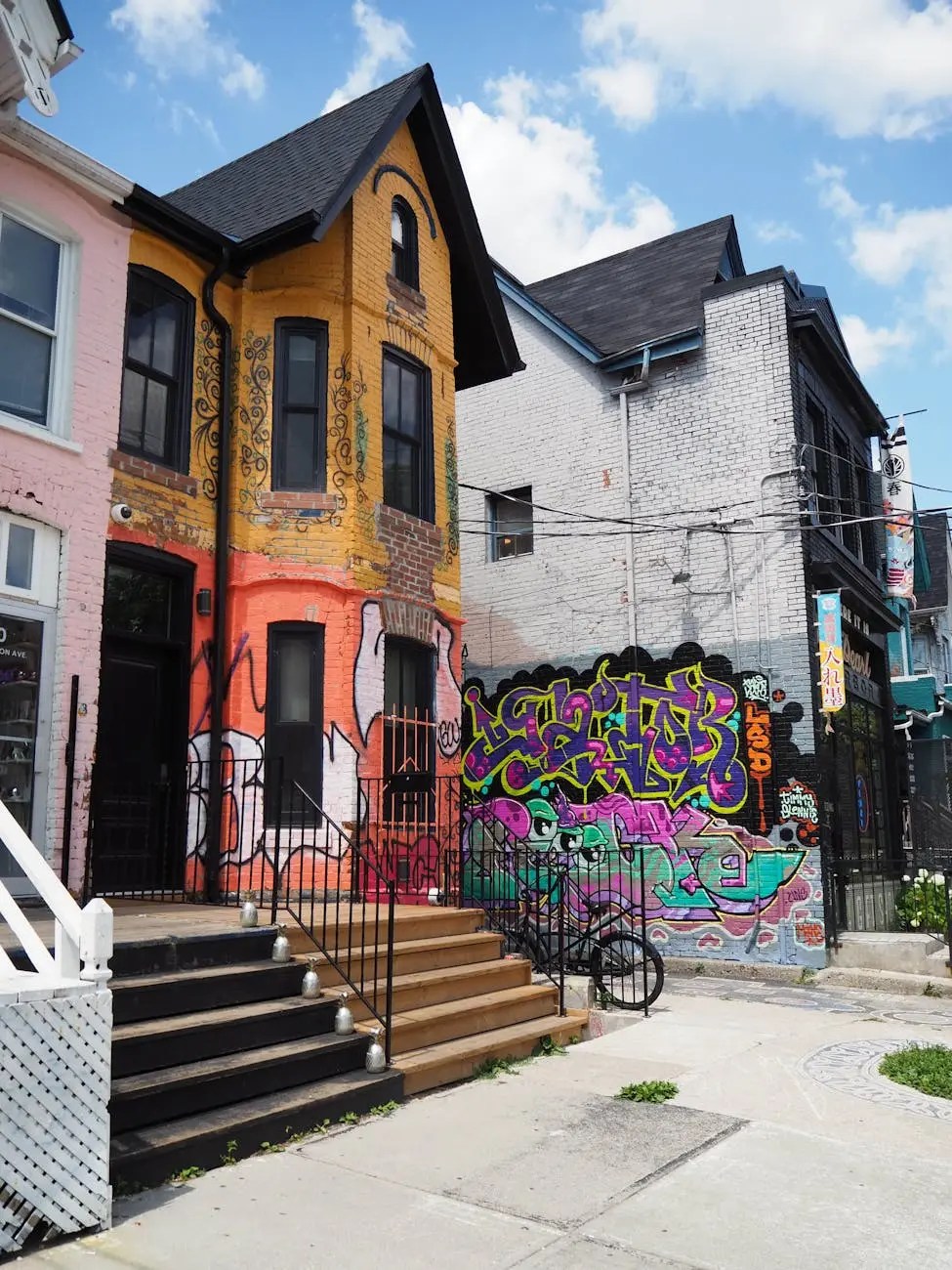 Colorful row houses featuring vibrant street art and graffiti in a Toronto neighborhood.