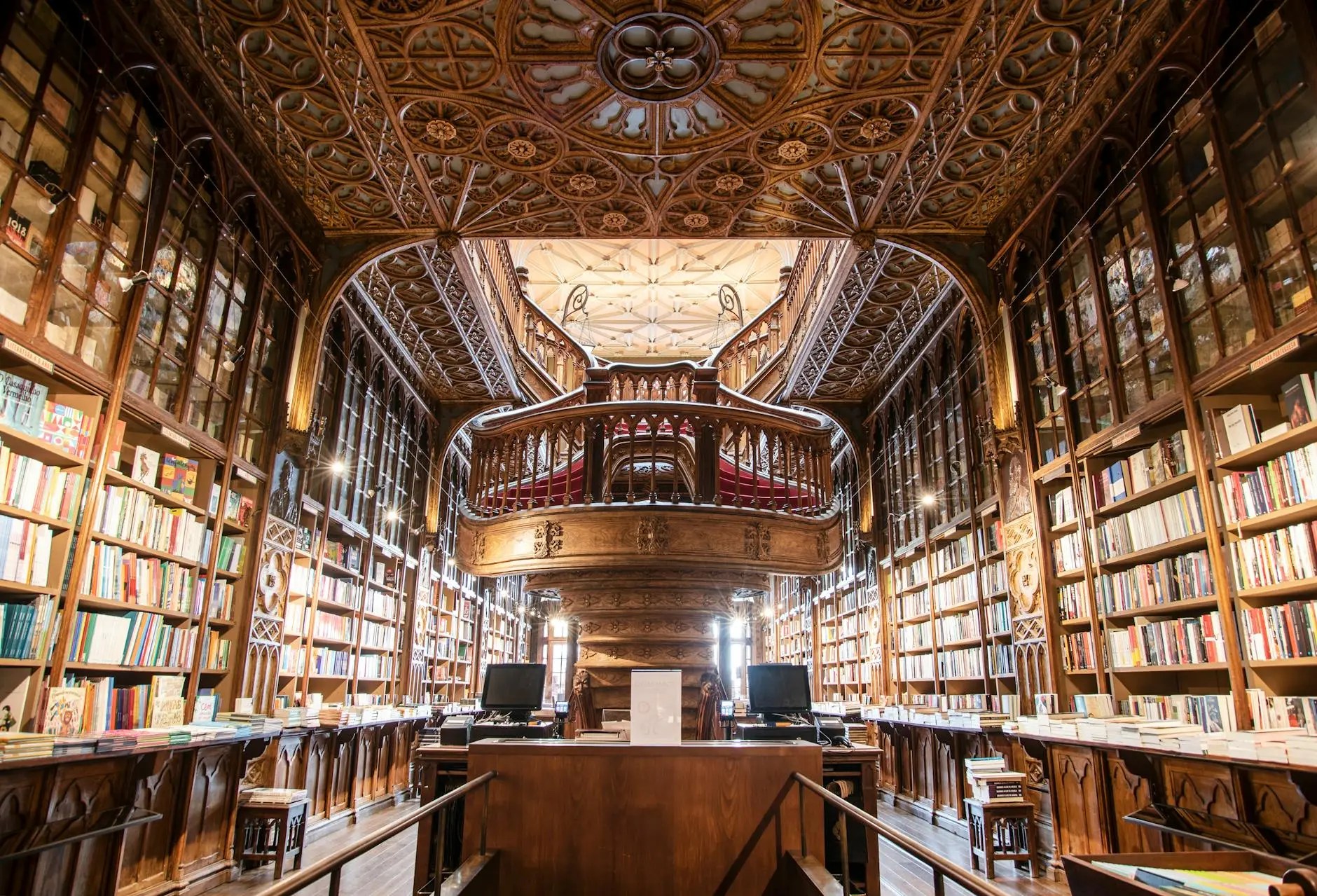 Interior view of Livraria Lello, a beautiful historic bookstore in Porto, featuring ornate woodwork, shelves filled with colorful books, and a grand staircase.