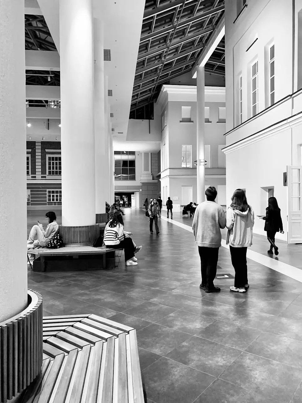 Interior view of a modern art museum featuring high ceilings, large columns, and visitors exploring the space.