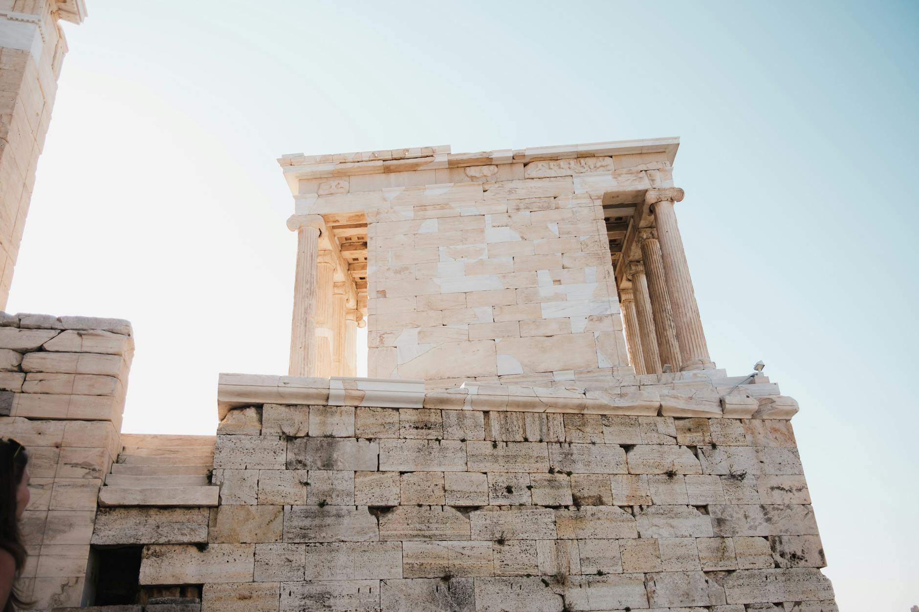 A close-up view of the ancient Temple of Athena Nike, showcasing its classical architecture against a clear blue sky.