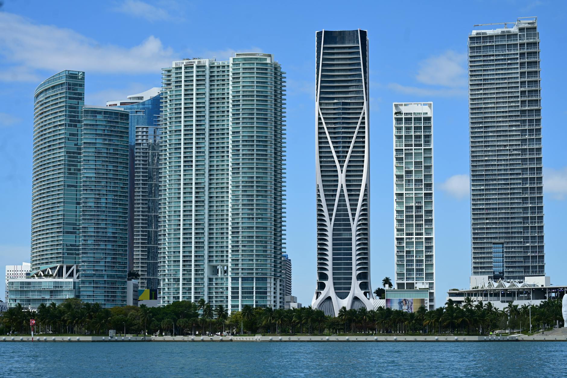A skyline view of Miami featuring modern skyscrapers along the waterfront under a clear blue sky.