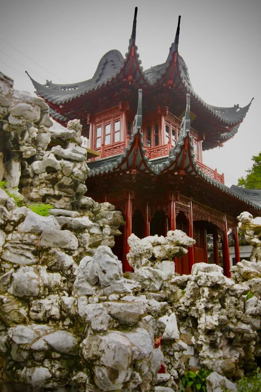 A traditional Chinese pavilion surrounded by rocky formations, set in a serene garden landscape.