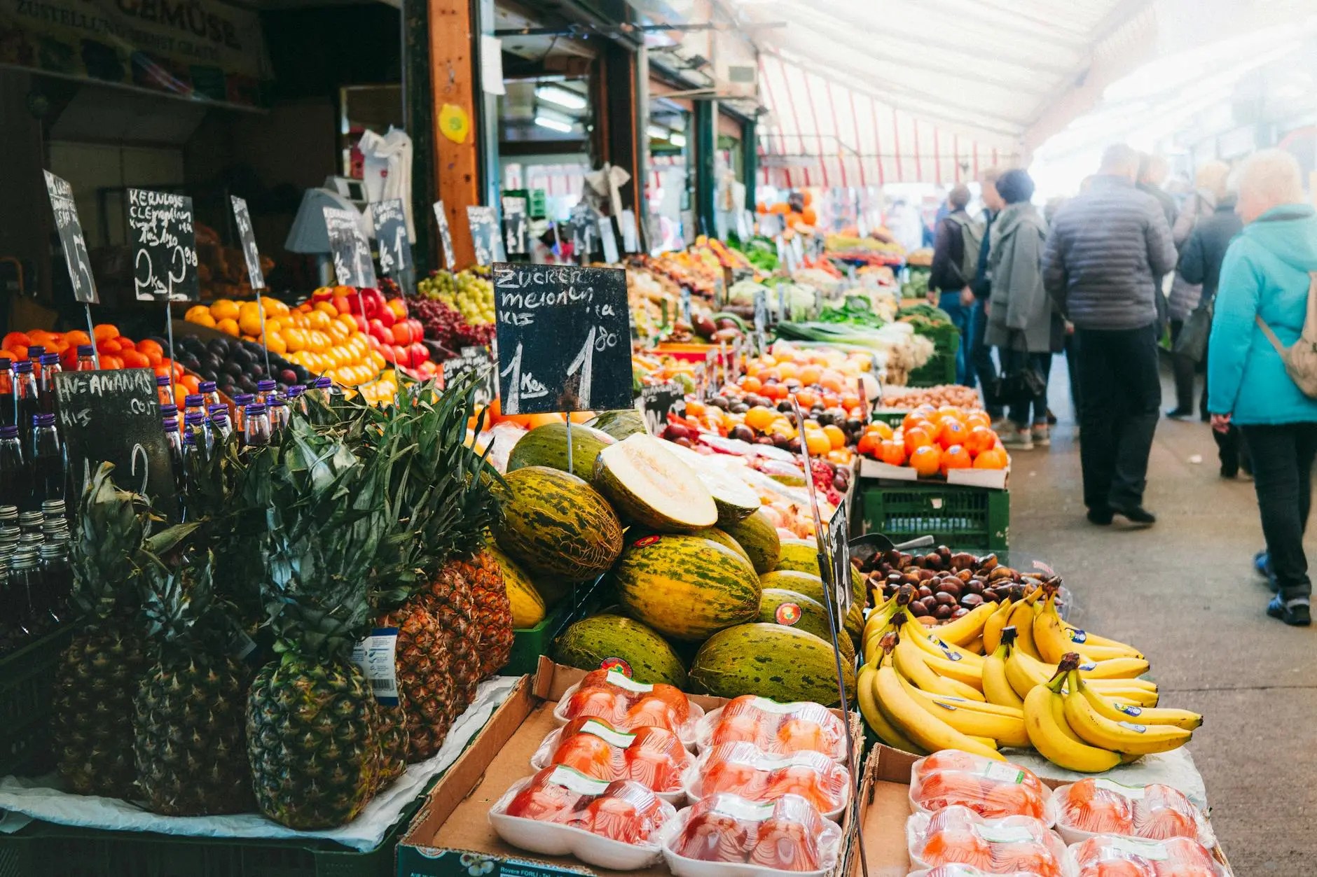 Vibrant market scene at Naschmarkt in Vienna, showcasing an array of colorful fruits and vegetables with shoppers exploring the stalls.