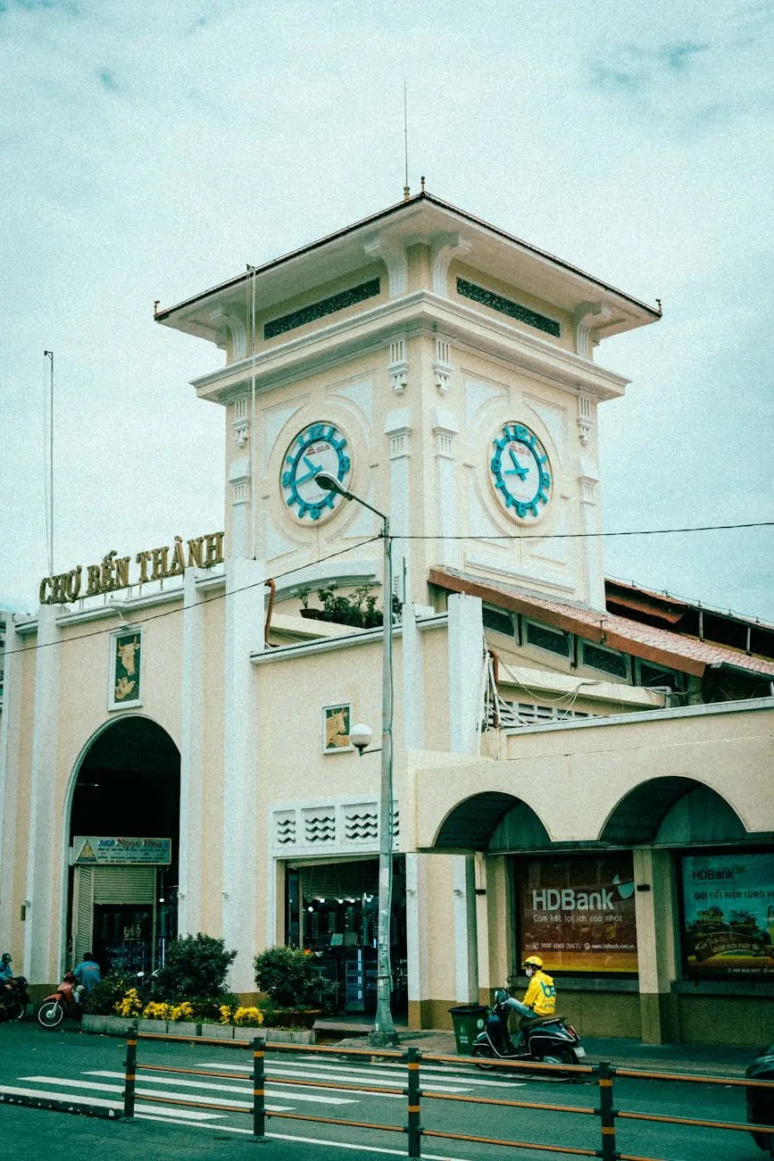 The exterior of Bến Thành Market in Ho Chi Minh City, showcasing its architectural features and two large clocks on the clock tower.