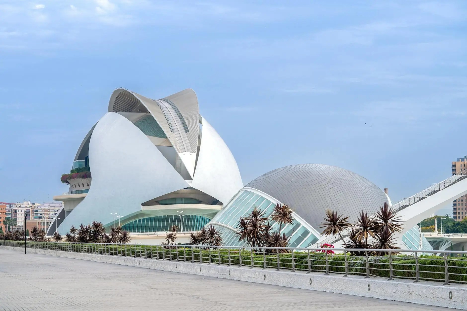 Futuristic architectural design of the City of Arts and Sciences in Valencia, Spain, featuring unique curves and shapes against a clear blue sky.