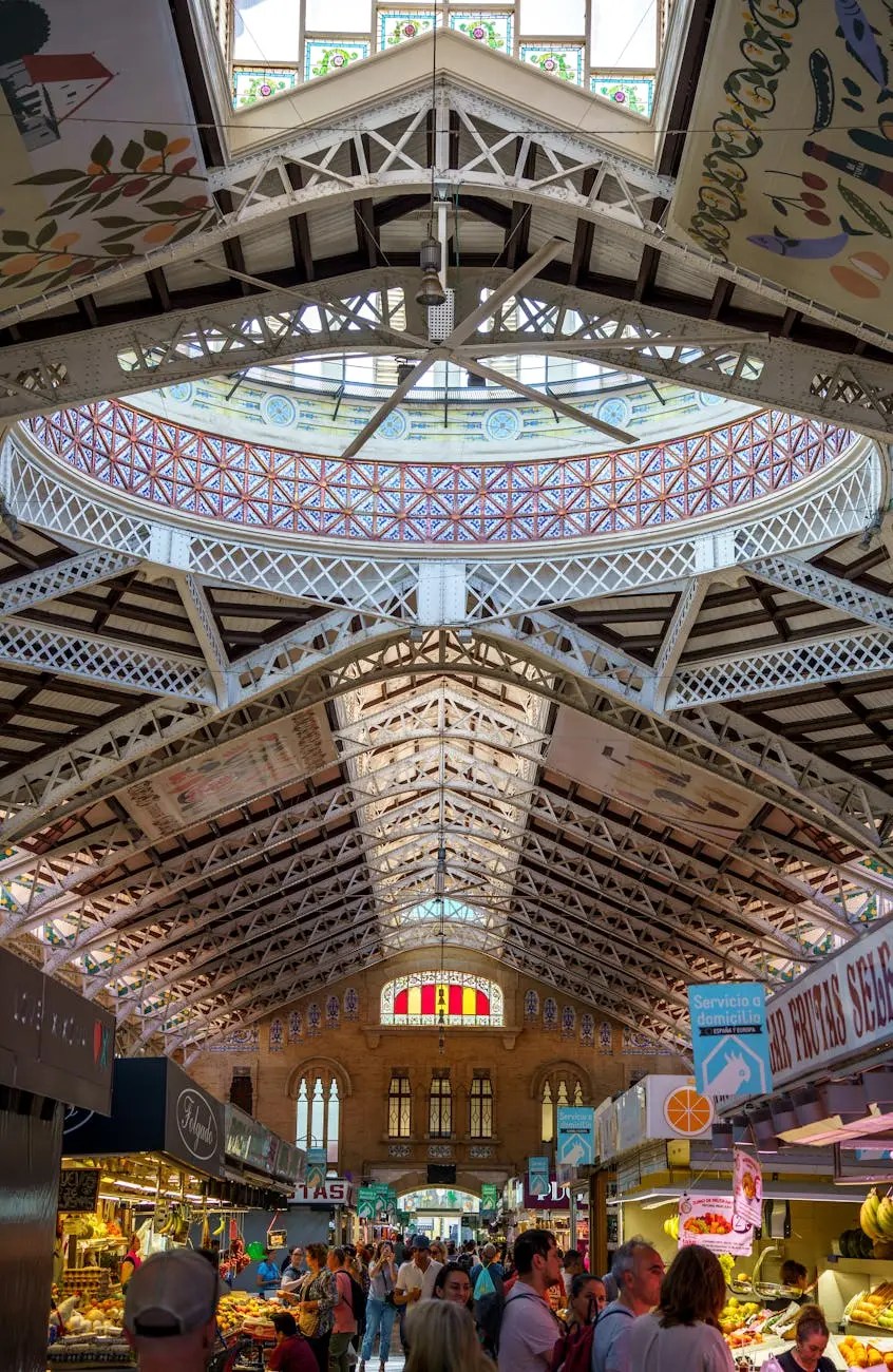 Interior view of the Mercado Central in Valencia, showcasing its beautiful Art Nouveau architecture and bustling atmosphere with shoppers browsing fresh produce.