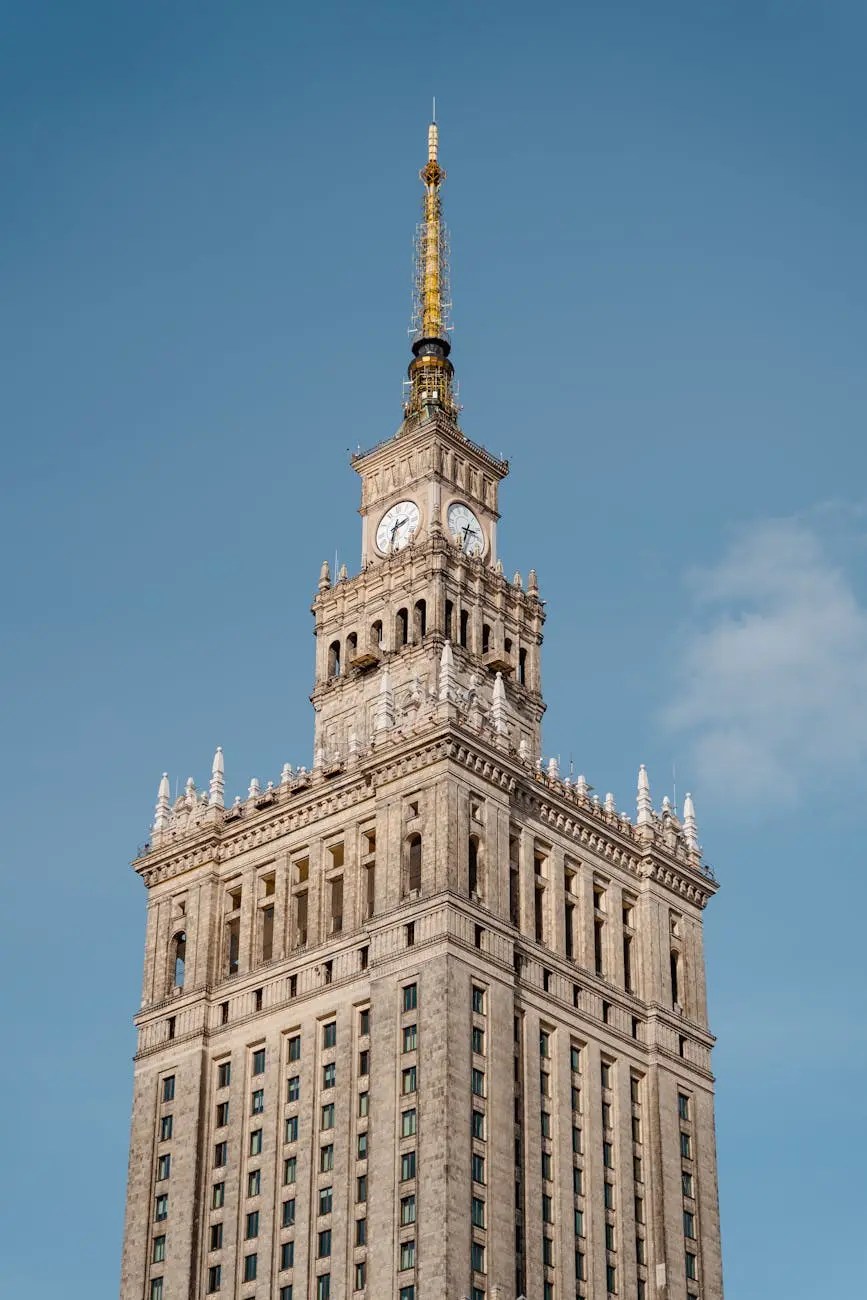Close-up view of the Palace of Culture and Science in Warsaw, Poland, showcasing its architectural details and golden spire against a clear blue sky.