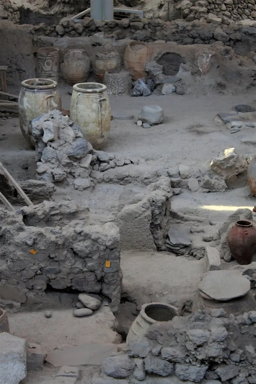 Archaeological site featuring ancient pottery and remnants of walls, showcasing the historical artifacts and structures from a past civilization.