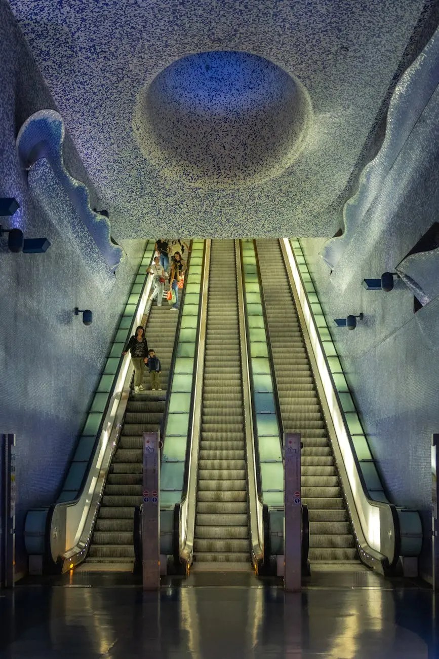 Interior view of a modern metro station in Naples featuring escalators illuminated by soft lighting and a blue patterned ceiling.
